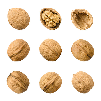 Walnuts, whole and opened, isolated on white background. Top views of the nuts and seeds of the common walnut tree Juglans regia, used as snack and for baking. Macro food photo close up from above.