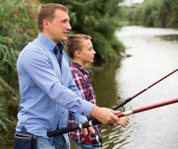 istock Father and son fishing on river 879608958