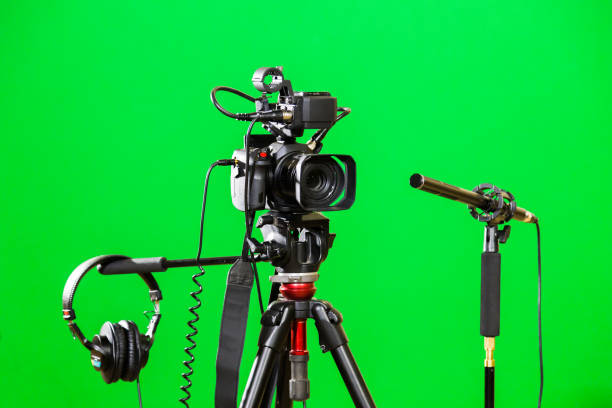 istock Video camera on a tripod, headphones and a directional microphone on a green background. The chroma key 879609382