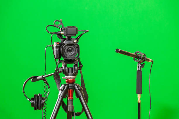 istock Video camera on a tripod, headphones and a directional microphone on a green background. The chroma key 879609416