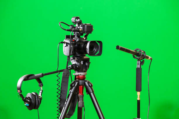 istock Video camera on a tripod, headphones and a directional microphone on a green background. The chroma key 879609432