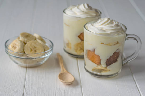 istock Banana dessert with whipped cream and biscuit on a white table. 879616074