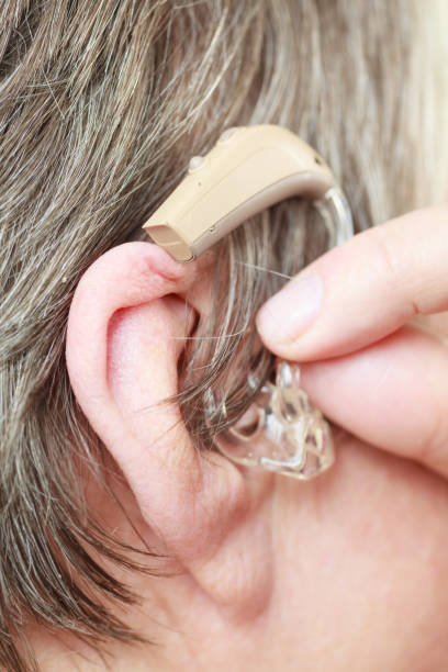 istock Closeup senior woman using hearing aid 879624042