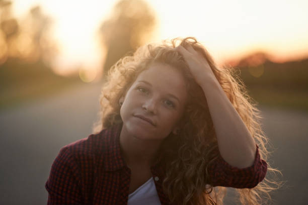 Portrait of an attractive young woman sitting on a road outside