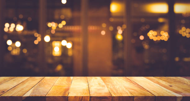 Wood table with blur light bokeh in dark night cafe Wood table top (Bar) with blur light bokeh in dark night cafe,restaurant background .Lifestyle and celebration concepts ideas food court photos stock pictures, royalty-free photos & images