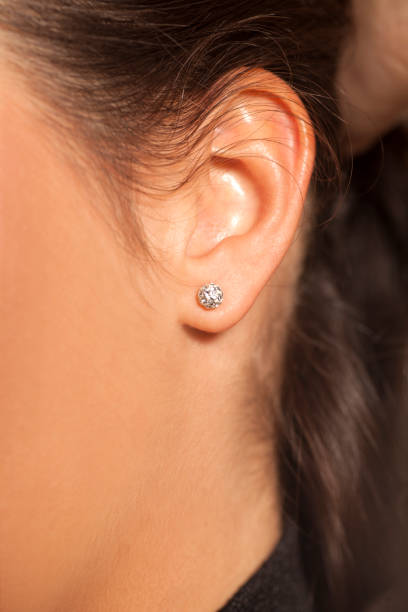 istock Closeup female ear with a small luxurious earring 879640488