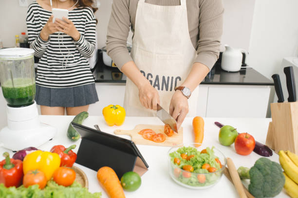 istock Handsome asian man chopping vegetables in the kitchen 879641130