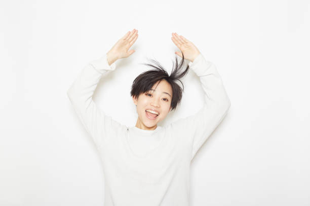 Studio shot photo of a young woman playing with her hair