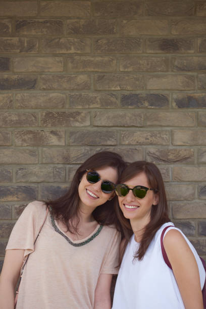 istock Two girls standing in front of brick wall 879651856