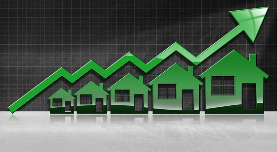 Growing real estate sales - 3D illustration of five house-shaped symbols and a graph of growth with a green arrow on a blackboard