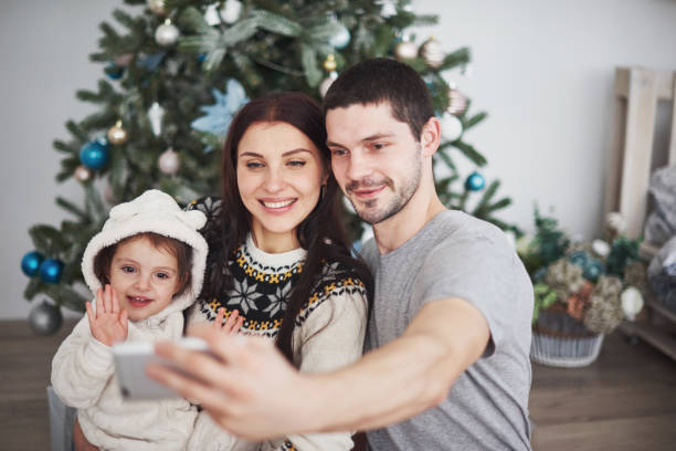 istock Family gathered around a Christmas tree, using a tablet 879652414