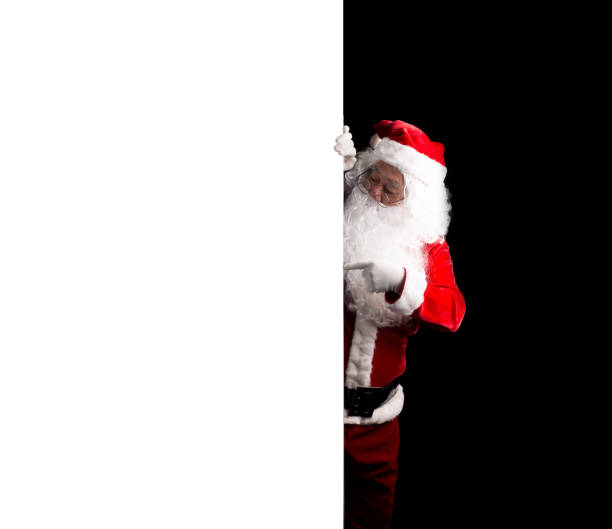 istock Santa Claus holding a white blank sign isolated on black  background 879655618