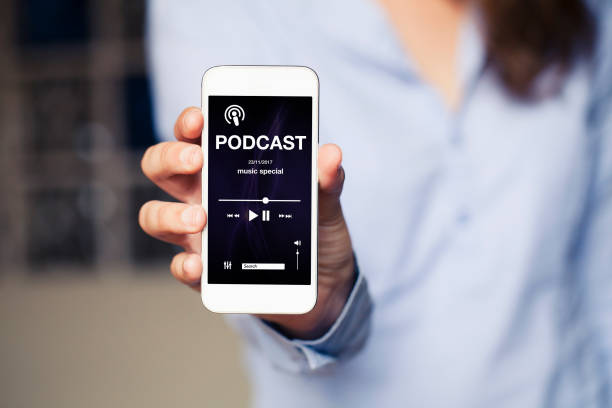 istock Podcast app in a phone screen while woman holds it in the hand. 879661558