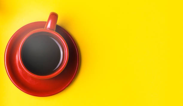 istock Red Cup with black coffee on a yellow background 879662206