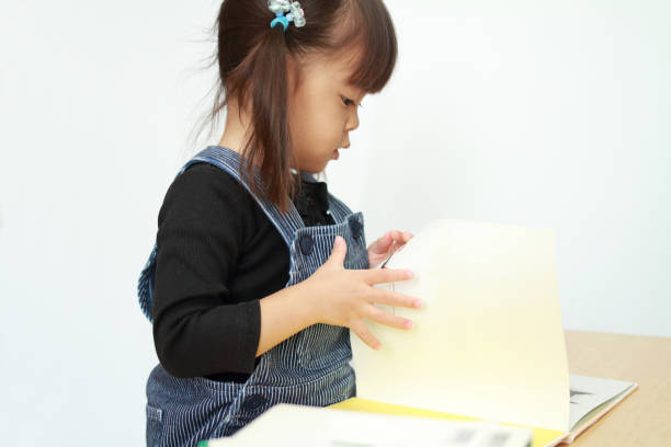 istock Japanese girl reading a picture book (3 years old) 879669610