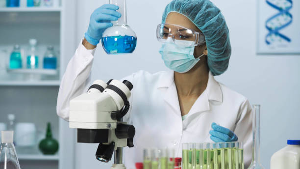 istock Biracial female scientist looking into microscope, doing biomedical research 879686176