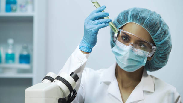istock Laboratory worker checking liquids transparency in medical tubes, close-up 879686388