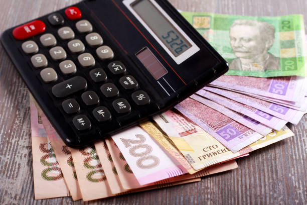 istock Coins and grivna banknotes with calculator 879686444