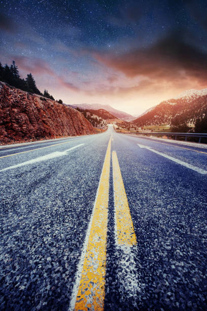 istock Asphalt road and lonely tree under a starry night sky and the Milky Way 879689744
