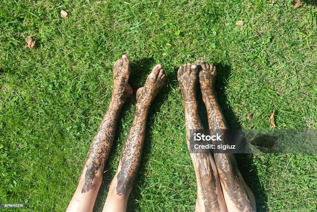 Naked dirty legs on the grass Top view legs of pretty young woman relaxing on grass Foot Stock Photo