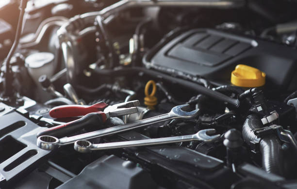 istock Mechanic hand checking and fixing a broken car in car service garage 879695970