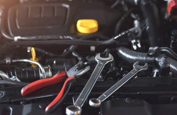 istock Mechanic hand checking and fixing a broken car in car service garage 879695990