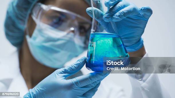 Investigador Observando La Reacción Química Después De Agregar Prueba Material En Frasco Foto de stock y más banco de imágenes de Sustancia química