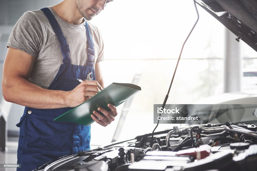 Retrato de un mecánico trabajando en su garaje - de coches, reparación, mantenimiento y la gente de concepto - Foto de stock de Coche libre de derechos