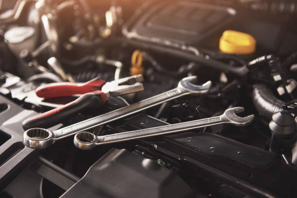 istock Mechanic hand checking and fixing a broken car in car service garage 879696416