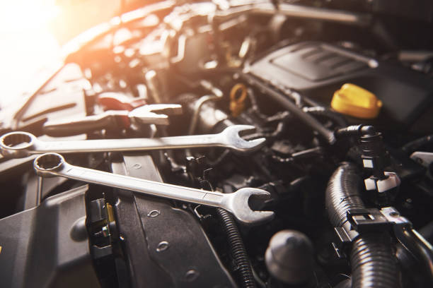 Mechanic hand checking and fixing a broken car in car service garage Mechanic hand checking and fixing a broken car in car service garage. motor vehicle stock pictures, royalty-free photos & images