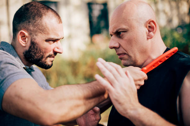 istock Knife threat. Kapap instructor demonstrates self defense knife threat disarming 879696920