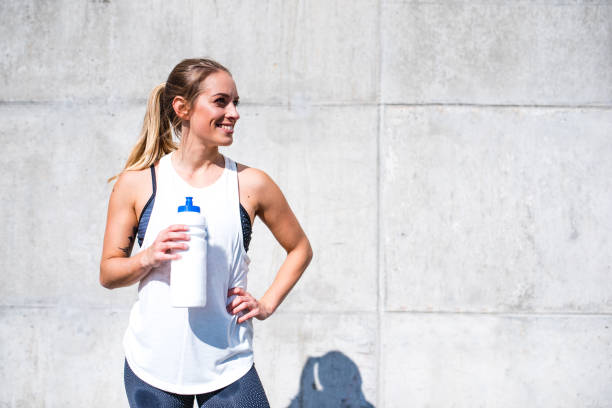 istock Woman drinking water after exercise 879708756