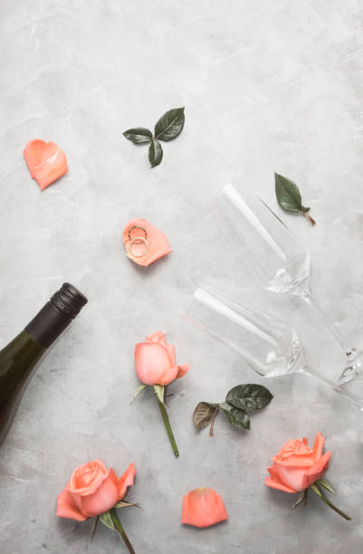 plat poser vue de dessus or bagues de mariage avec des roses et des verres de champagne sur grey\ - champagne wedding pink petal photos et images de collection