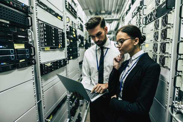 istock Handsome man and attractive woman are working in data centre. 879720032
