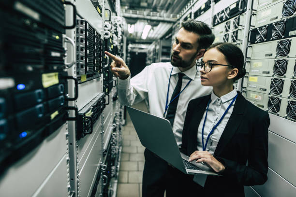 Handsome man and attractive woman are working in data centre.