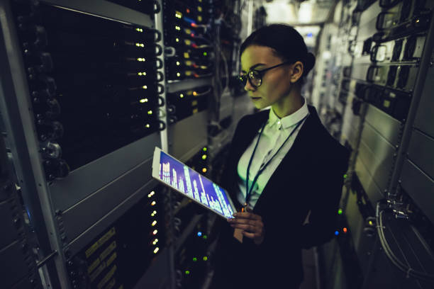 istock Attractive woman is working in data centre with tablet. 879720074