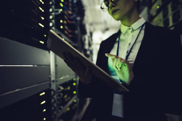 istock Attractive woman is working in data centre with tablet. 879720086