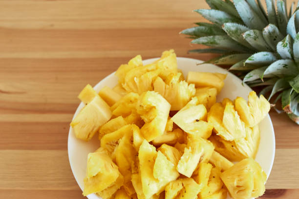 istock Sliced Pineapple White Plate on Wooden 879723204