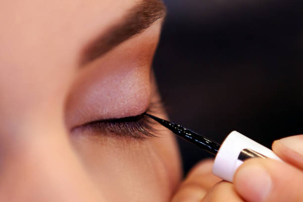 piękna kobieta stosująca eyeliner - brushing women make up ceremonial makeup zdjęcia i obrazy z banku zdjęć