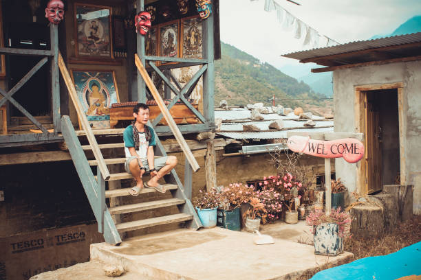 Phallus souvenir shop in Bhutan. Lobesa Village, Punakha, Bhutan - September 11, 2016: Phallus souvenir shop in Bhutan. Man sitting on the stairs. phallus shaped stock pictures, royalty-free photos & images