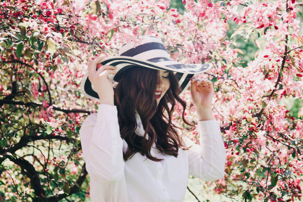 istock Girl in a hat in blossoming trees. 879733148