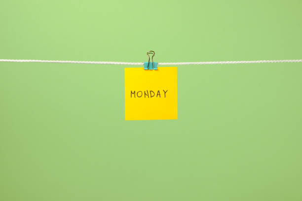 istock Yellow paper sheet on the string with text Monday over colorful background 879735786