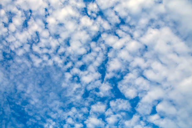 istock Fancy shapes of flying clouds in blue sky 879736488