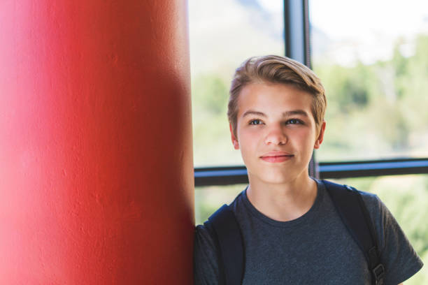 istock Thoughtful teenage boy leaning on red column 879743960