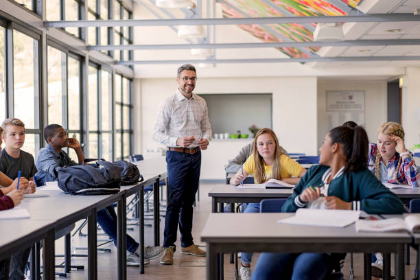istock Male professor looking female student in classroom 879746572