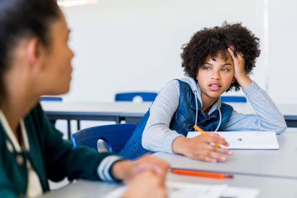 istock Female teenage students sitting in classroom 879746668