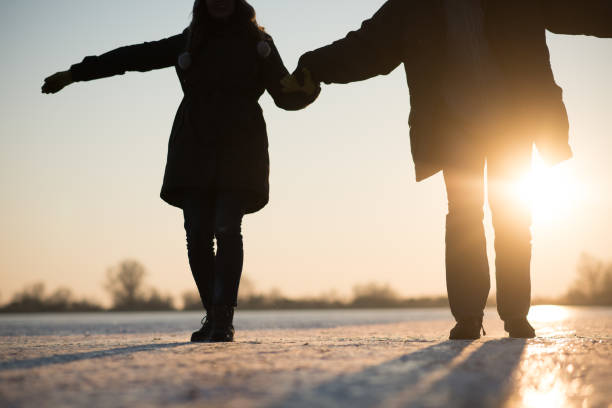 istock Romantic couple carefully stepping on frozen ice. 879763274