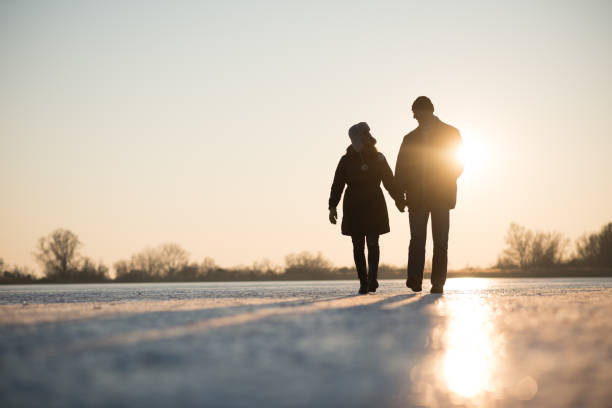 любовь пара ходить, держась за руки - lake night winter sky стоковые фото и изображения