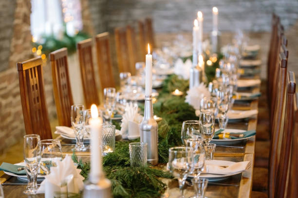 nature, winter, table setting concept. among clean plates, sparkling glasses, candle holders and other silverware there is lots of fresh and aromatic branches of some fur tree stock photo