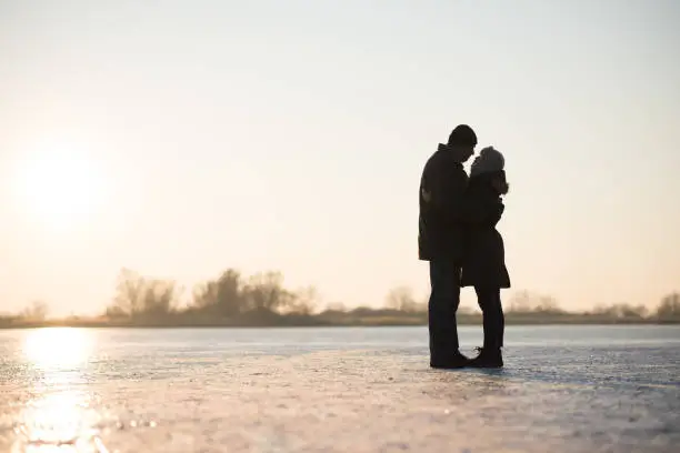Romantic couple embracing in winter landscape